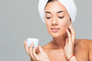 beautiful woman using skin care cream