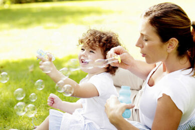 Mother and daughter playing with soap bubbles